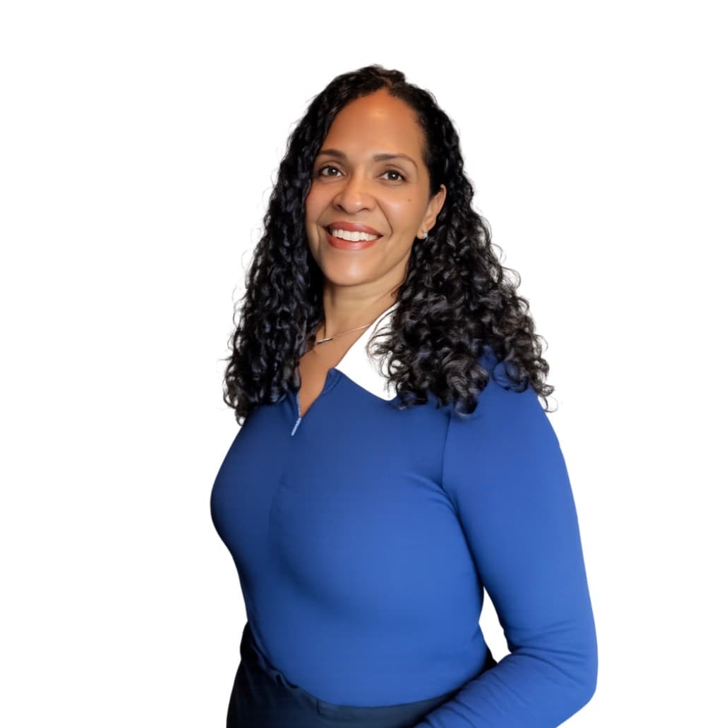 Smiling woman with long, dark, curly hair wearing a blue top with a white collar.