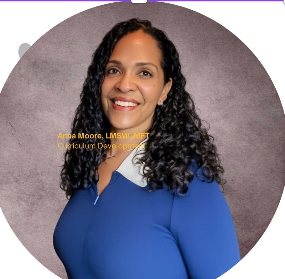 Anna Moore, LMSW, MFT, smiling with long curly hair, wearing a blue collared shirt.